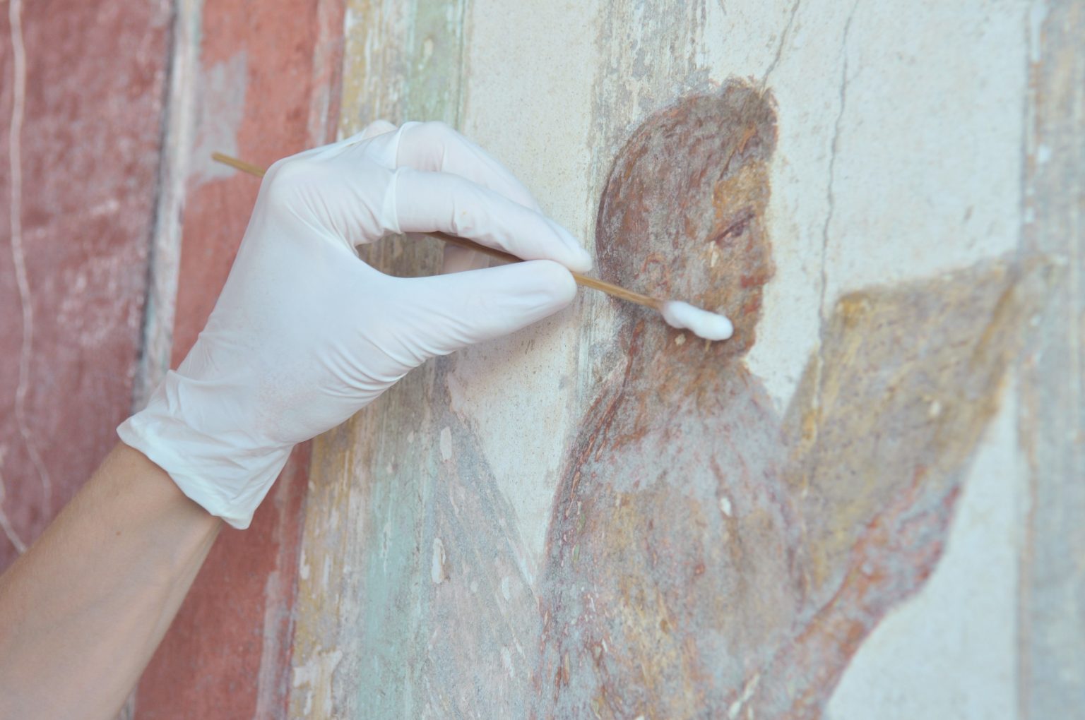 Oczyszczanie malowidła przedstawiającego czytającą postać.