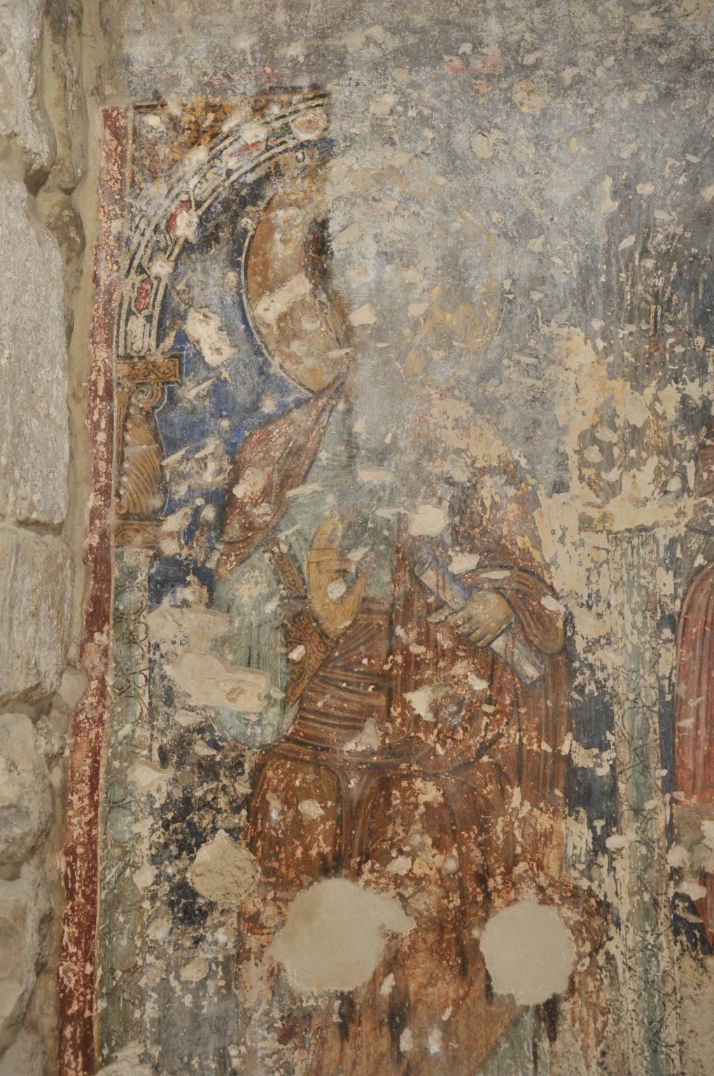Fragment malowidła w trakcie oczyszczania. Widoczna stojąca postać świętego.