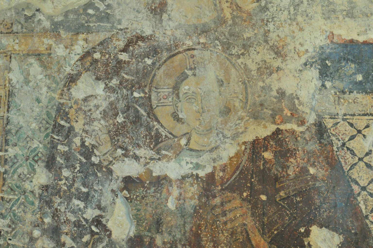 Fragment malowidła z przedstawieniem Matki Boskiej z Dzieciątkiem w trakcie oczyszczania. Widoczne dwie chronologiczne warstwy malowideł.