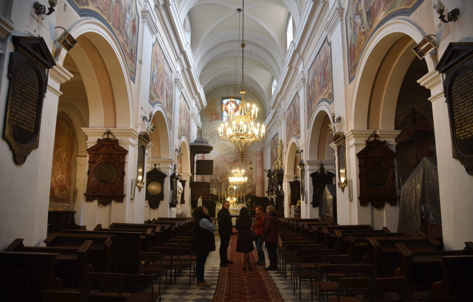 Grupa ludzi stoi w nawie głównej