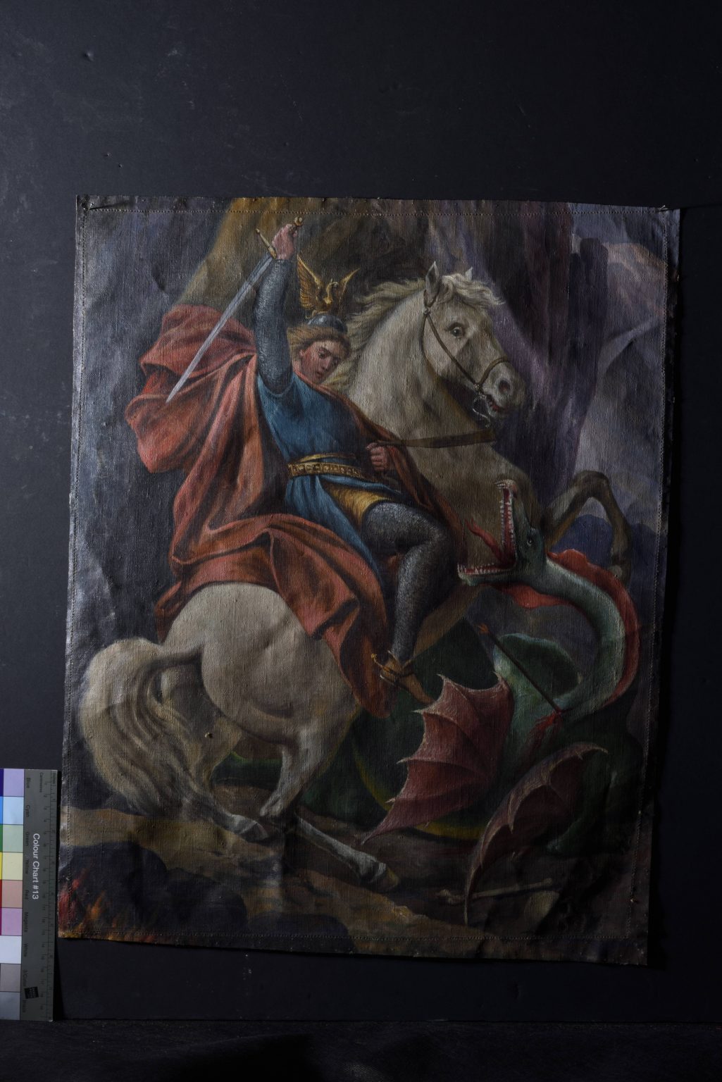 mężczyzna na koniu mieczem zamachuje się na smoka.