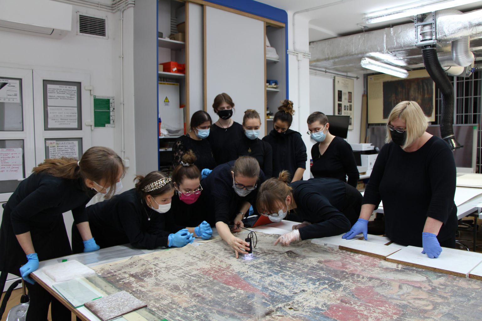 Grupa ludzi obserwuje prace restauratorskie