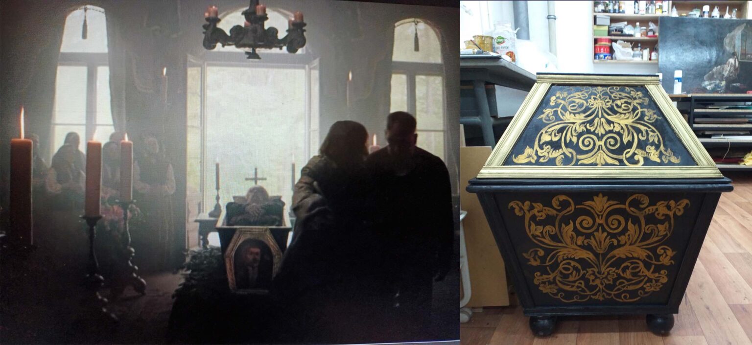 scena pogrzebu. Trumna wystawiona przy otwartych drzwiach