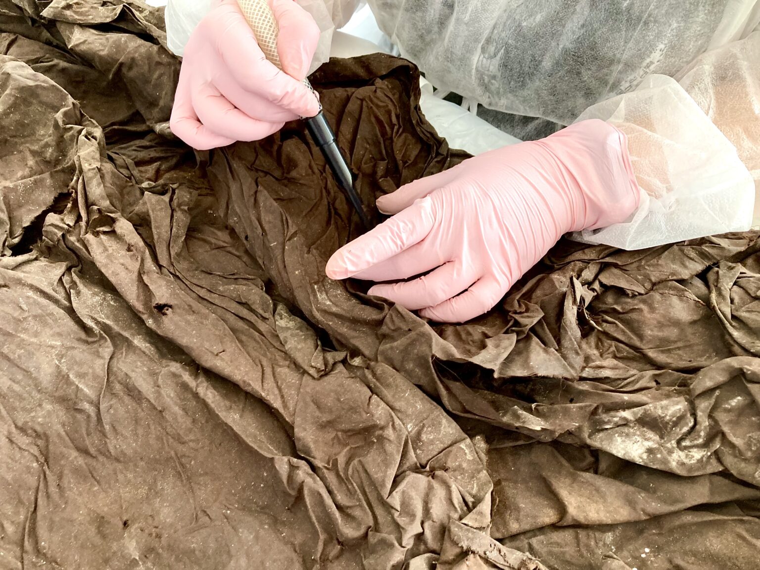 dłonie w rękawiczkach ochronnych wykonują czynności konserwatorskie